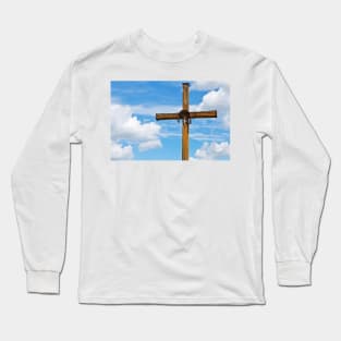 Figurine of Jesus Christ on a wooden cross against under blue cloudy sky Long Sleeve T-Shirt